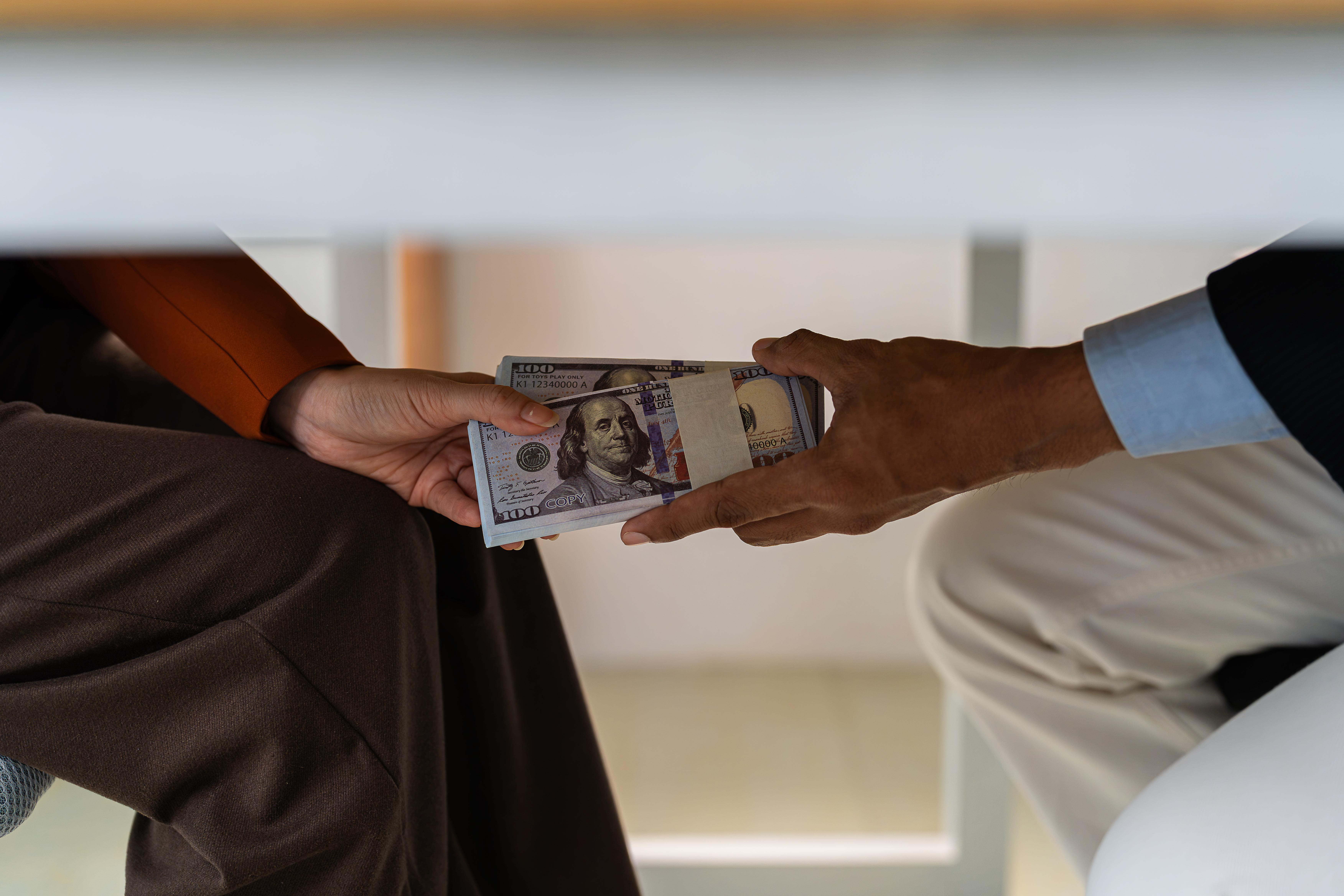 Businessman secretly giving money bribe to law officer or partner under a contract agreement.